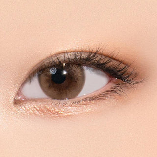 Close-up shot of model's eye adorned with Gemhour Selene Hazel color contact lenses with prescription, complemented by minimalist eye makeup, showing the brightening and enlarging effect of the circle contact lens on dark brown eyes.