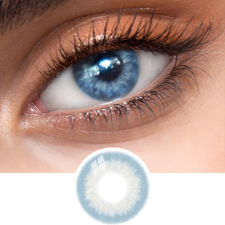 Close-up view of EyeCandys Sugarlook Blue contact lens on a model's dark eye, paired with natural eye makeup, above the graphic design of the blue eye contacts.