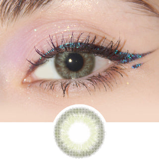 Close-up view of EyeCandys Sugarlook Green contact lens on a model's dark eye, paired with natural eye makeup, above the graphic design of the green eye contacts.