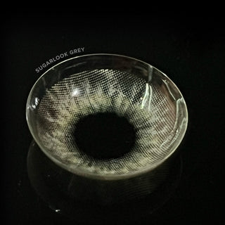 Detailed image of EyeCandys Sugarlook Grey contact lens with a contrasting dark backdrop