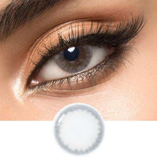 A blue circle contact lens on top of a brown eye with smoky eye makeup and long eyelashes, above the design of the contact lens itself.