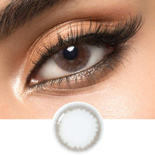 A grey circle contact lens on top of a brown eye with smoky eye makeup and long eyelashes, above the design of the contact lens itself.