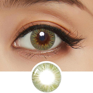 Close-up photo displaying the Birthday Green contact lens on a white background, featuring a model with dark brown eyes and minimal eye makeup. The image also includes a cut-out of the contact lens.