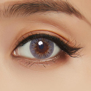 Close-up image highlighting the model's eye adorned with Birthday grey contact lens, paired with peach eyeshadow