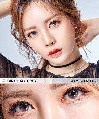 Asian model showcases Birthday Grey contact lenses, with hands raised above her head, delicately touching her hair, accentuating the enhanced eyes from the grey contacts in a close-up photo.