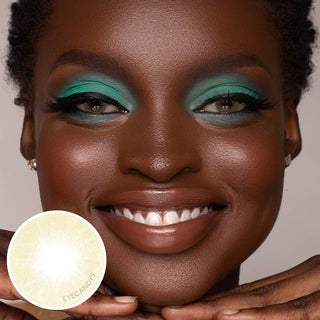 Dark-skinned model wearing Glossy Ivory hazel color contact lenses on top of her dark irises, with bright turquoise eyeshadow, next to a cutout of the lens design.