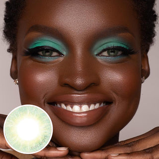 A black model with naturally dark brown eyes and green eyeshadow, wearing EyeCandys Libre green contact lenses, showcases a joyful expression.
