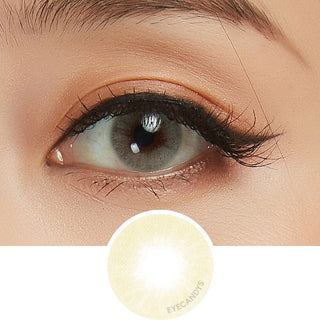 Glossy Ivory beige colour contact lens worn on a dark eye paired with neutral eye makeup, above the contact lens design itself.